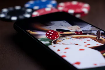 A professional dealer in a tuxedo greeting players at the roulette table, symbolizing the authentic live casino feel at AMJILI.
