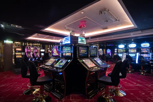 A woman in a luxurious green gown next to an ornate roulette wheel, capturing the upscale casino mood of AMJILI.
